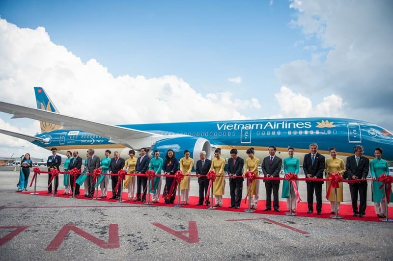 Staff and dignitaries in front of a Vietnam airlines plane