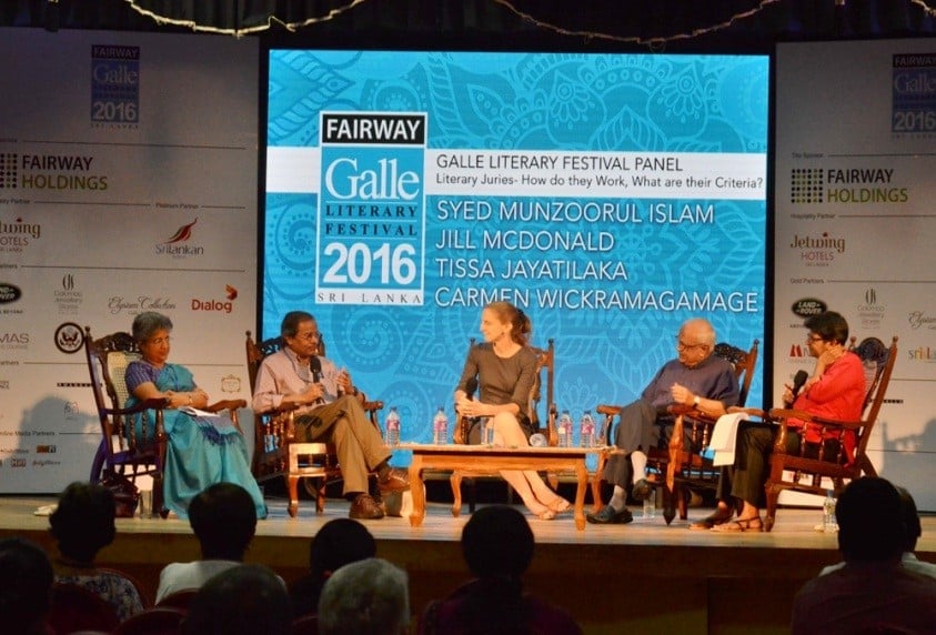 five authors on stage at the galle literary festival with a screen with while and blue colours behind them