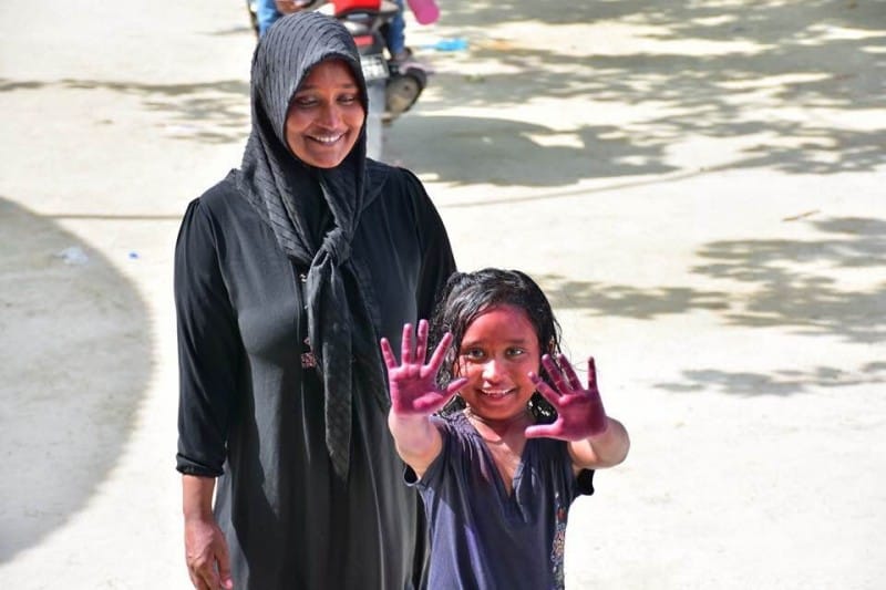 Young muslim girl shows the palms of her hands with paint