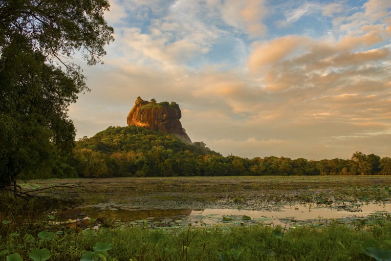 A view of Sigirya Rock Fortress from afar with a water body in between