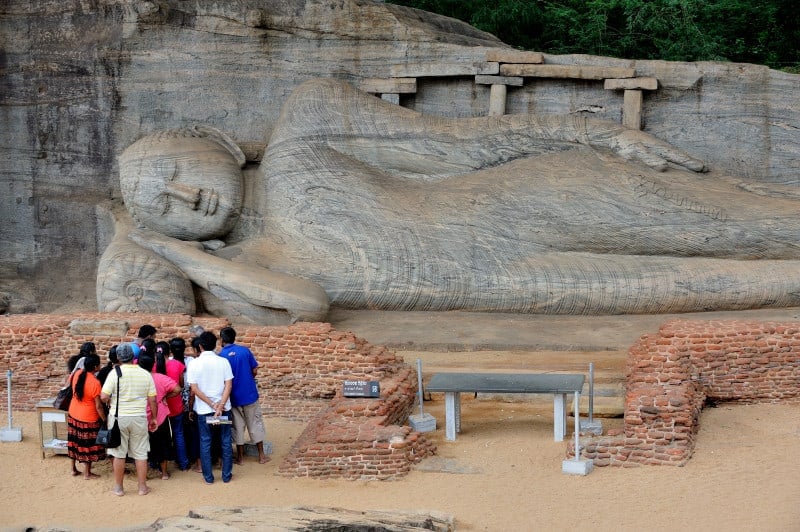 Gal Viharaya Buddha at Polonnaruwa with tourists and a guide looking on