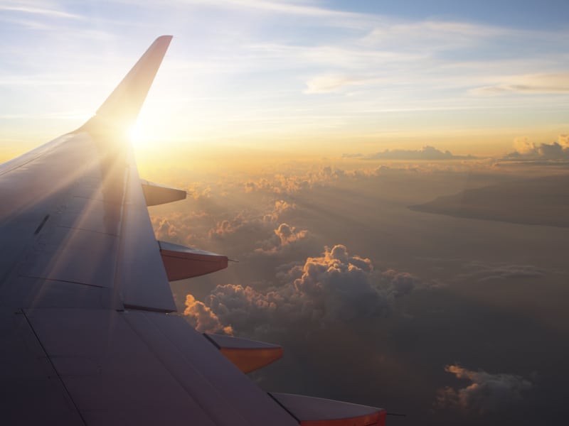 View of the sunset,clouds and airplane wing from the Inside