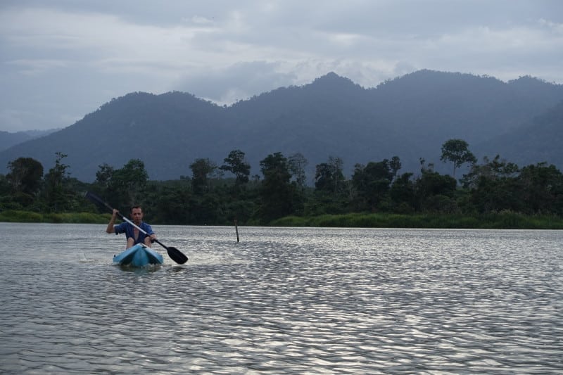 Traveller kayaking on Chenderoh Lake in Malaysia