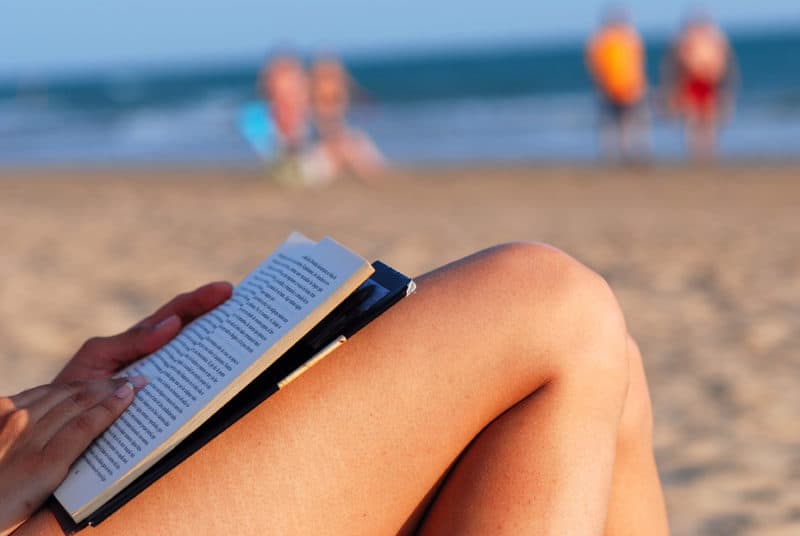 reading a book whilst in the sun on the beach