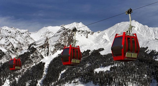 Solang valley ropeway with snow topped mountains in the background