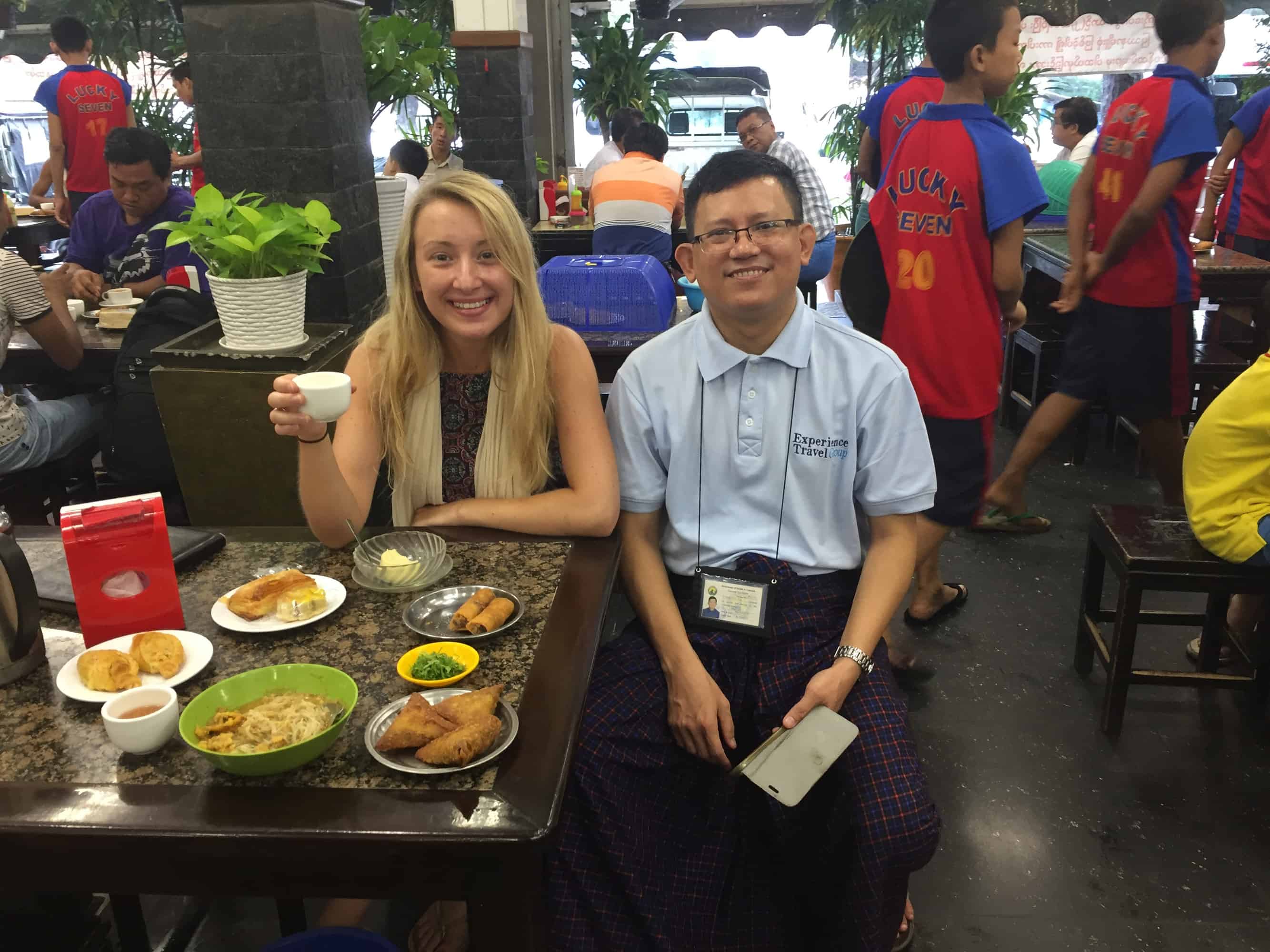 A guide and traveller sat together in a restaurant in myanmar