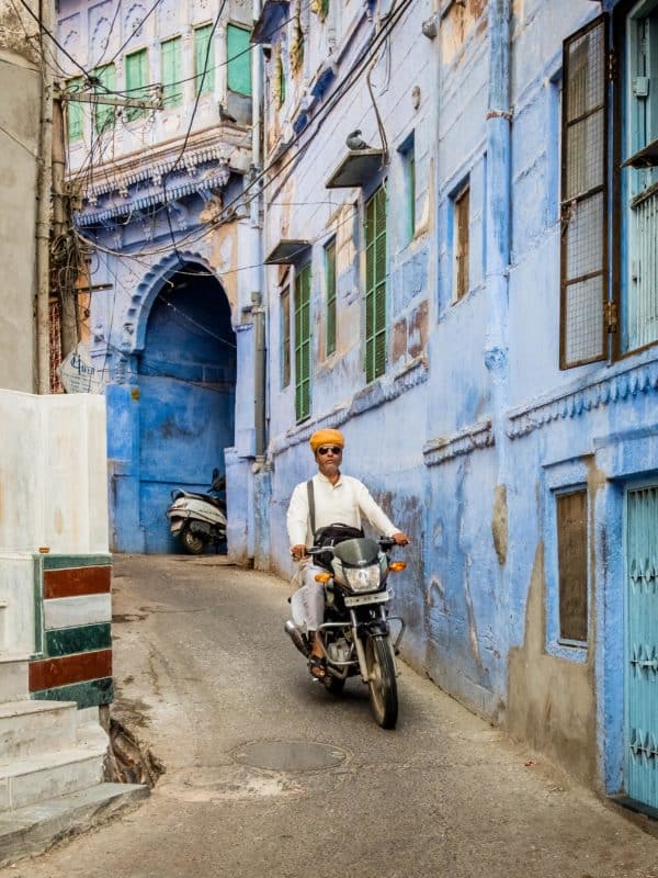 Moped rider in narrow alleyway in the blue city of Jodhpur