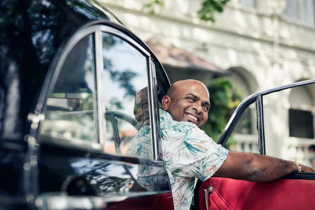 Driver in Sri Lanka in a morris minor outside Amangalla in Galle