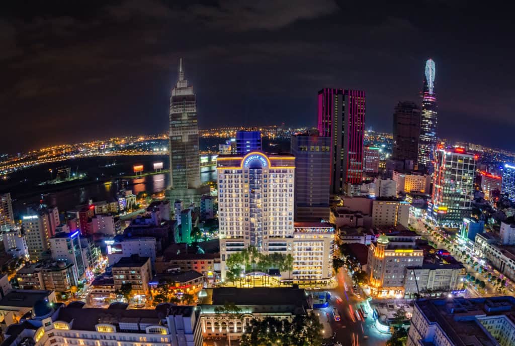 View of the Caravelle hotel at night from above as the buildings surrounding it are lit up