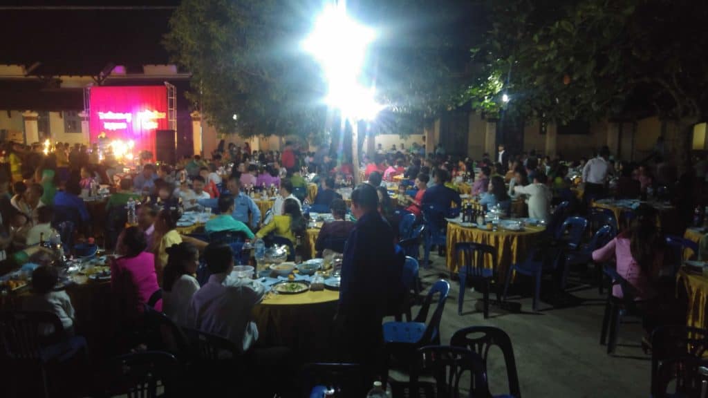 Guests seated at tables during a local lao wedding in Luang Prabang