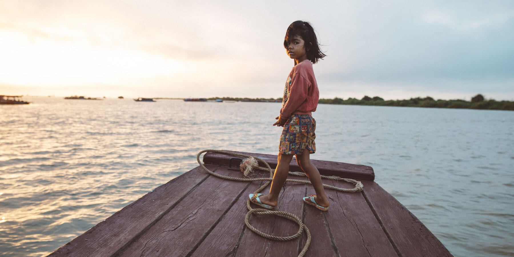 Child stood on boat on the Tonle Sap Lake in Cambodia