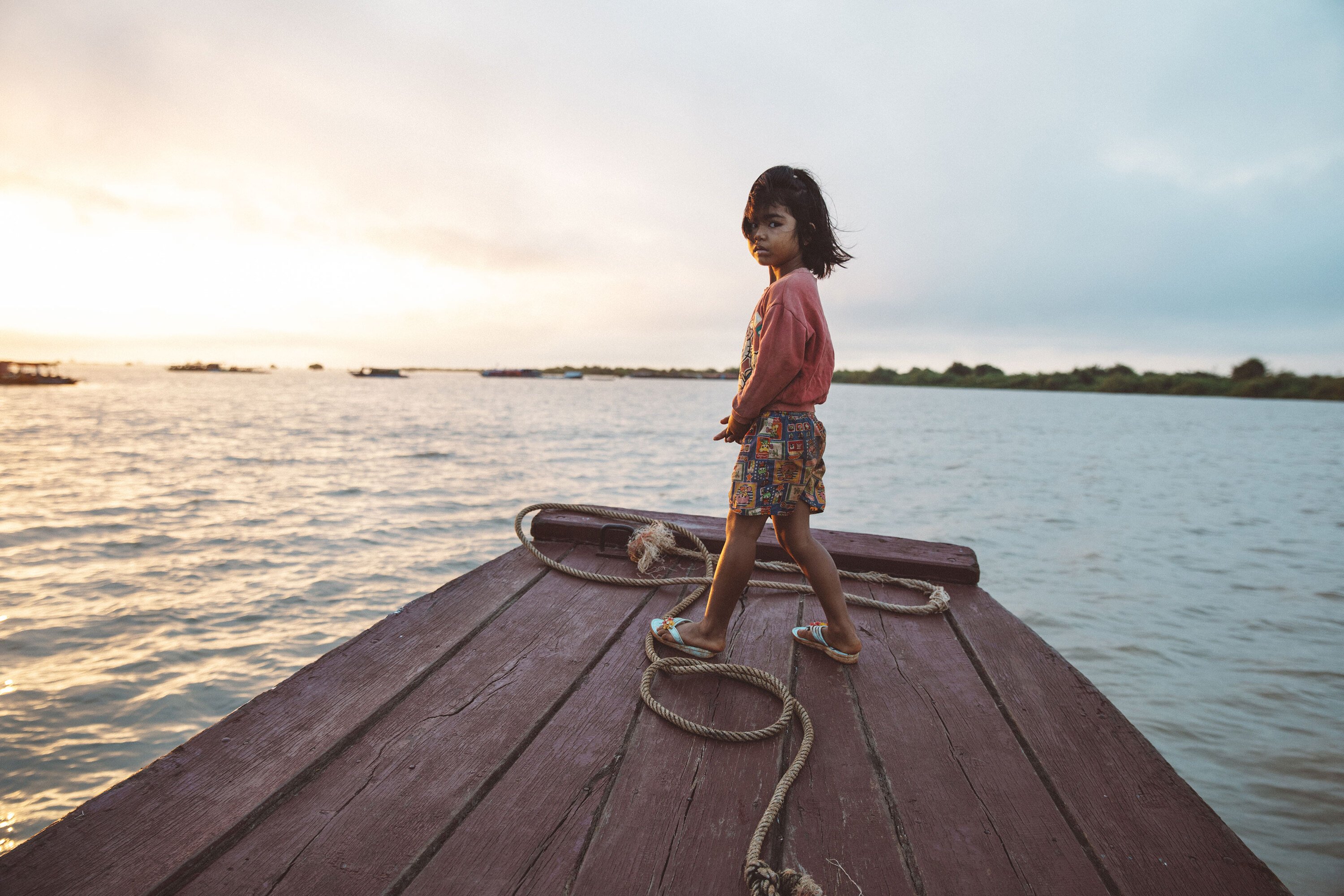 Child stood on boat on the Tonle Sap Lake in Cambodia