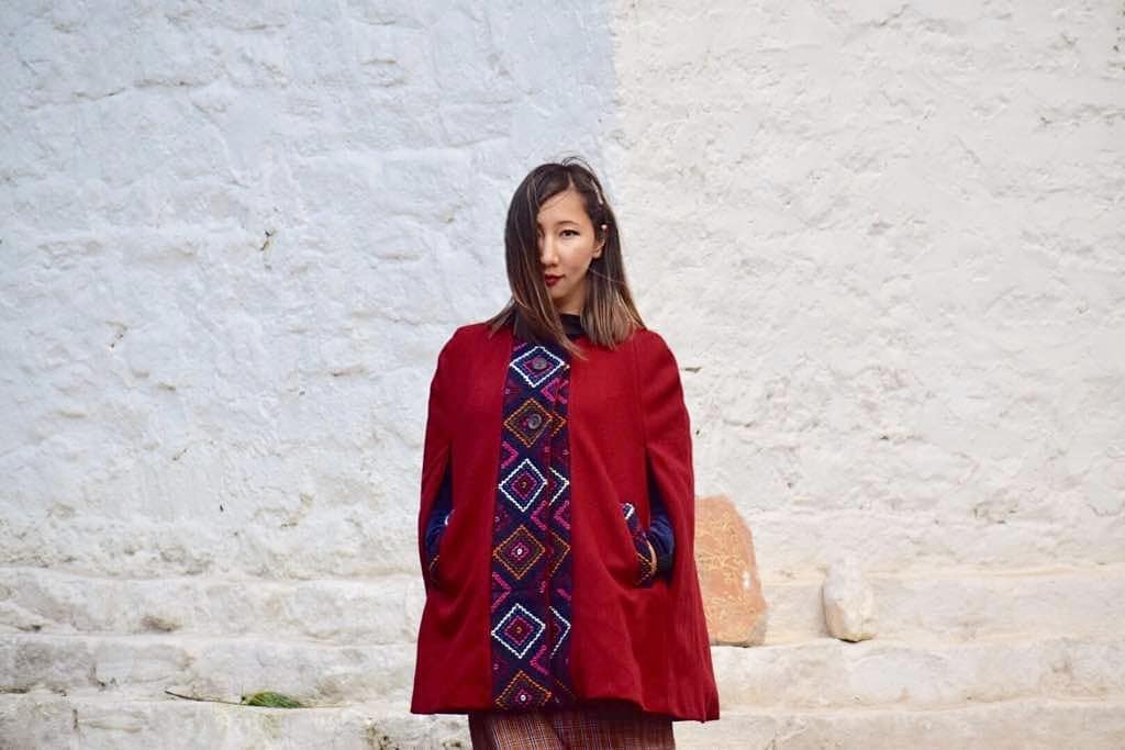 Geymit wearing a She Bhutan maroon cape yathra jacket