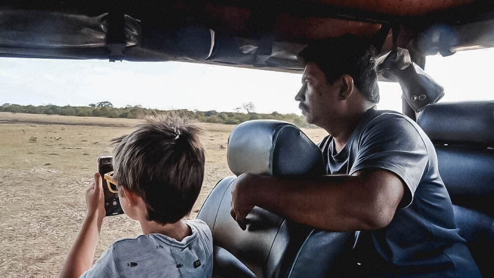 A friendly guide helping a boy spot wildlife on a Sri Lanka Family Holiday with ETG