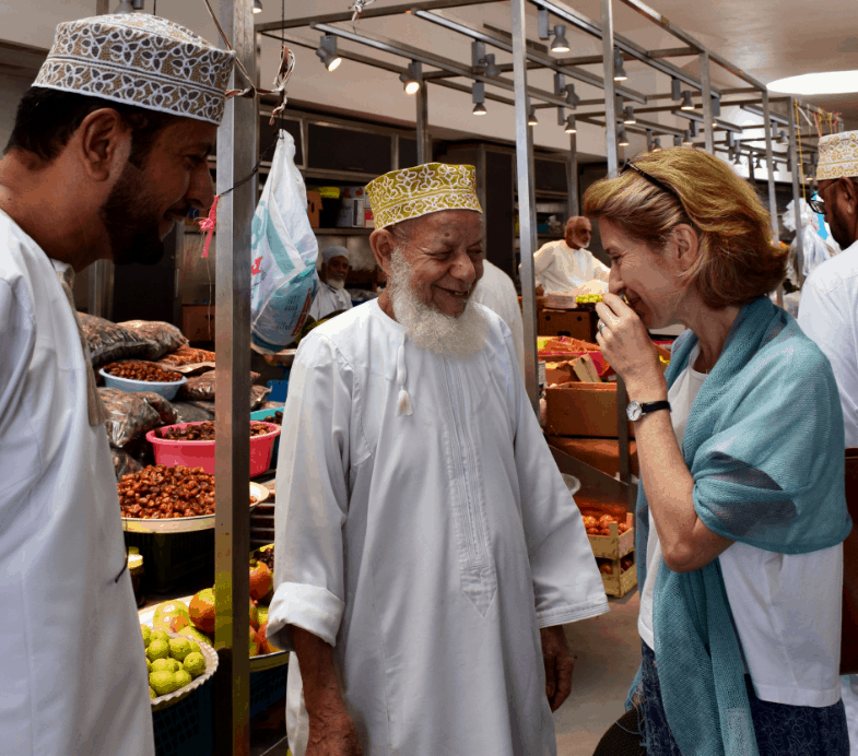 Traveller laughing with guide in Oman market