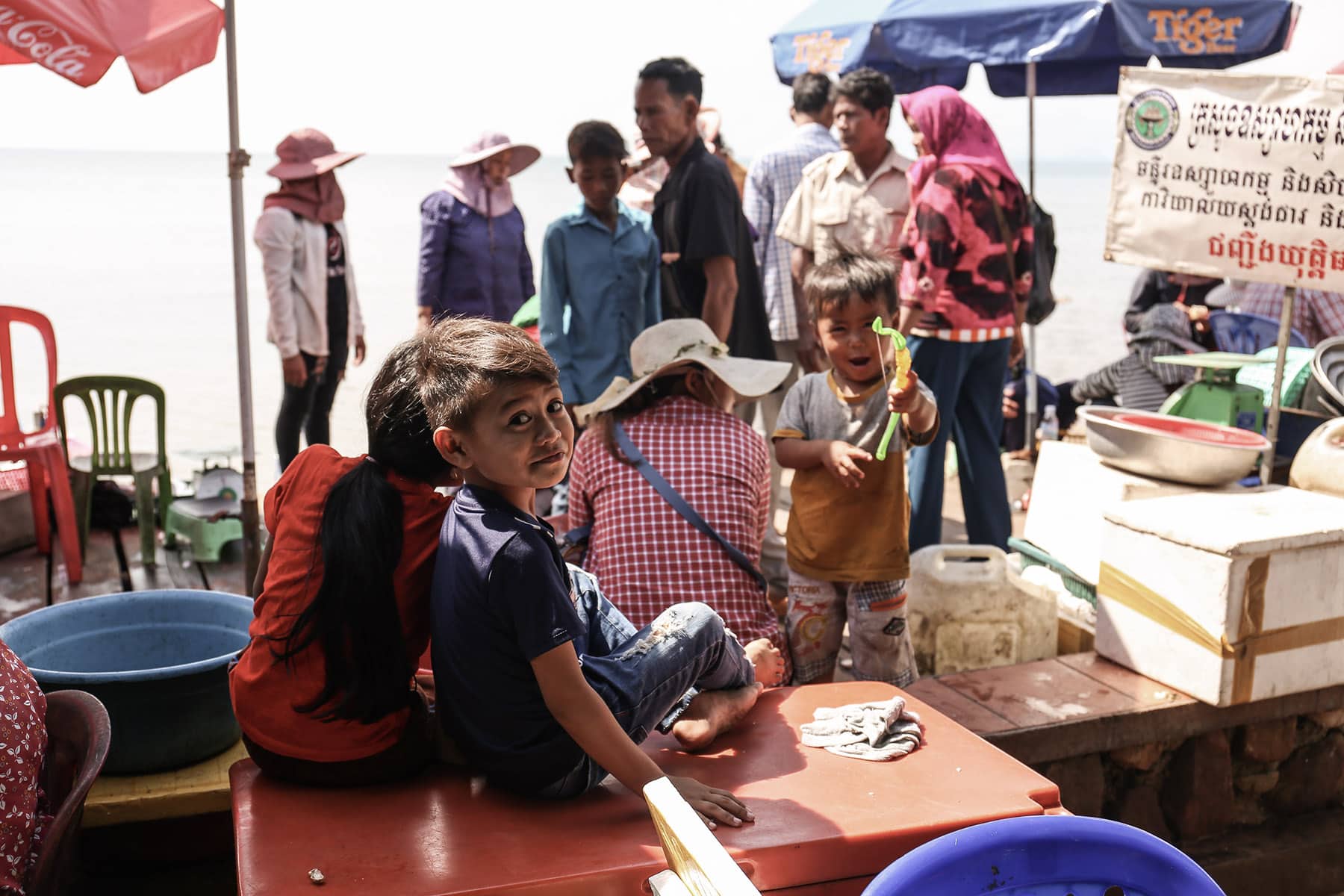 Children staring at Kep crab markek whilst business is being conducted