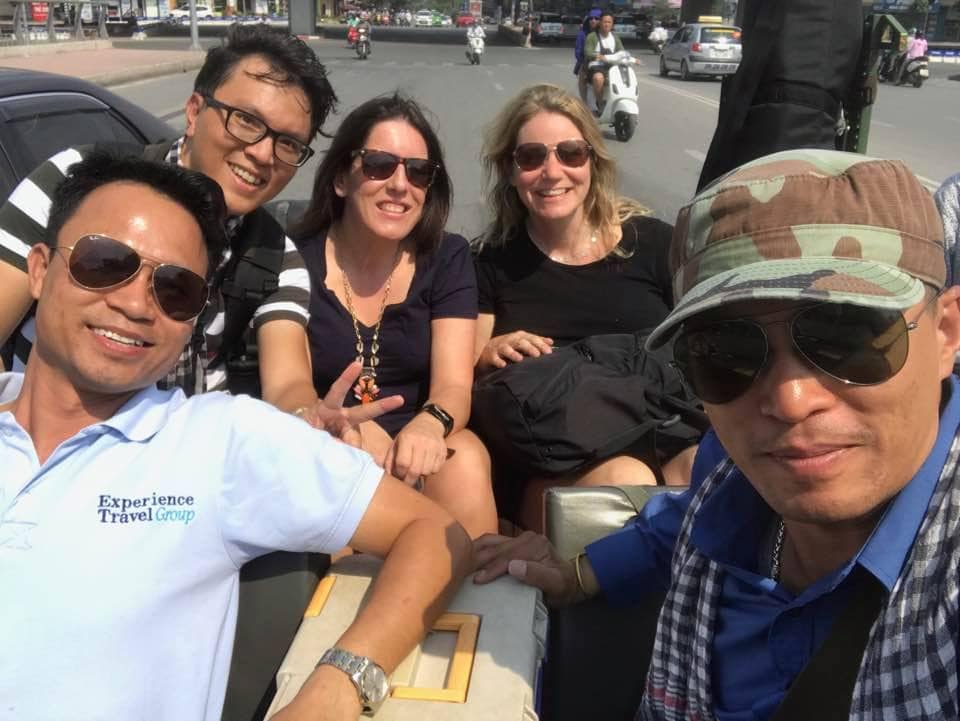 Guides and travellers in the back of an open top vehicle having fun in Vietnam