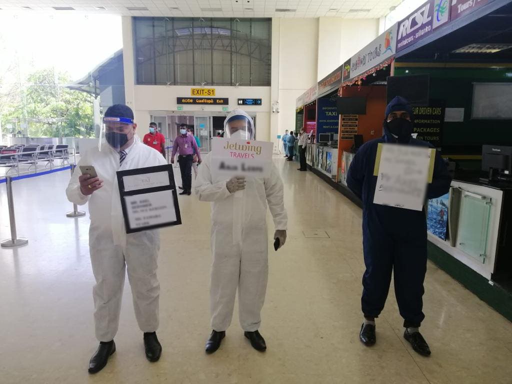 Guides wearing hazmat suits in the arrivals of Colombo airport in Sri Lanka