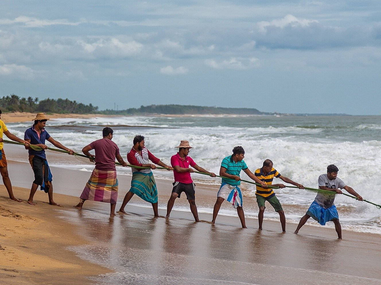 Men hauling in fish on Sri Lankan beach at Ravana Garden hotel