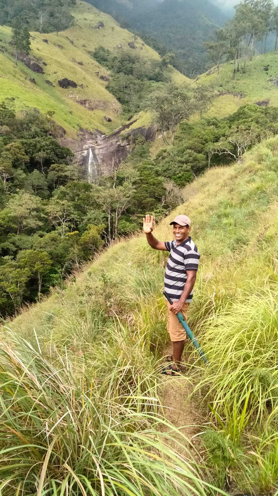 Trekking guide smiling with Lanka Ella waterfall in the background