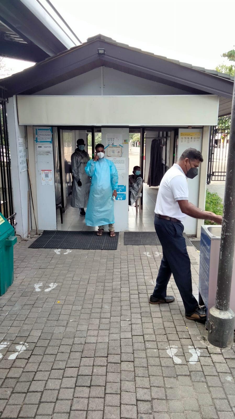 Staff outside Temple of the Tooth ensuring hand sanitising takes place and temperatures are logged