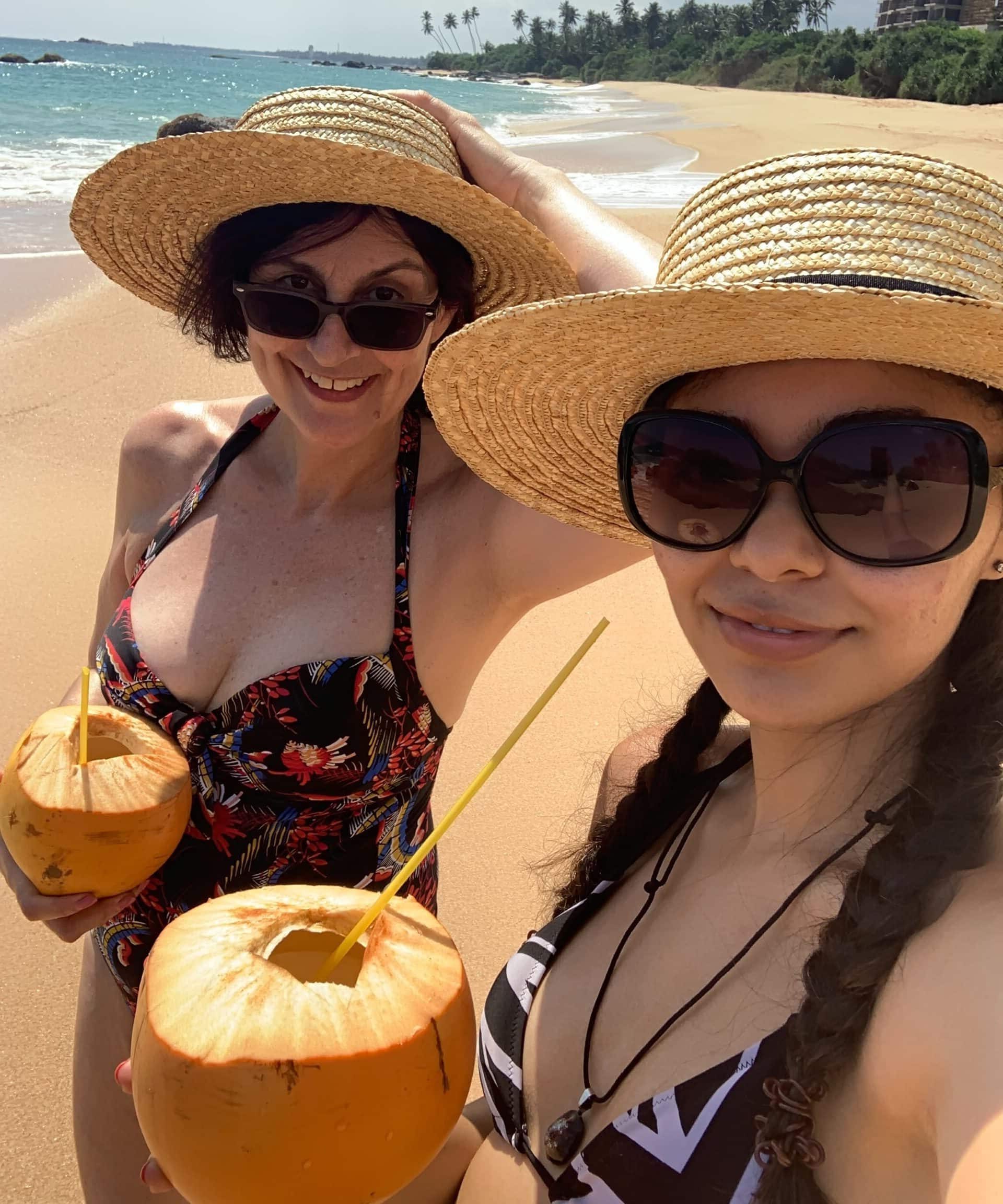 Jess and Karen enjoying kings coconuts on the beach in Sri Lanka