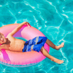 Young boy laying in a rubber ring in a swimming pool