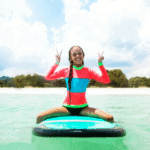 Young girl sitting on bodyboard along the coastline in Thailand