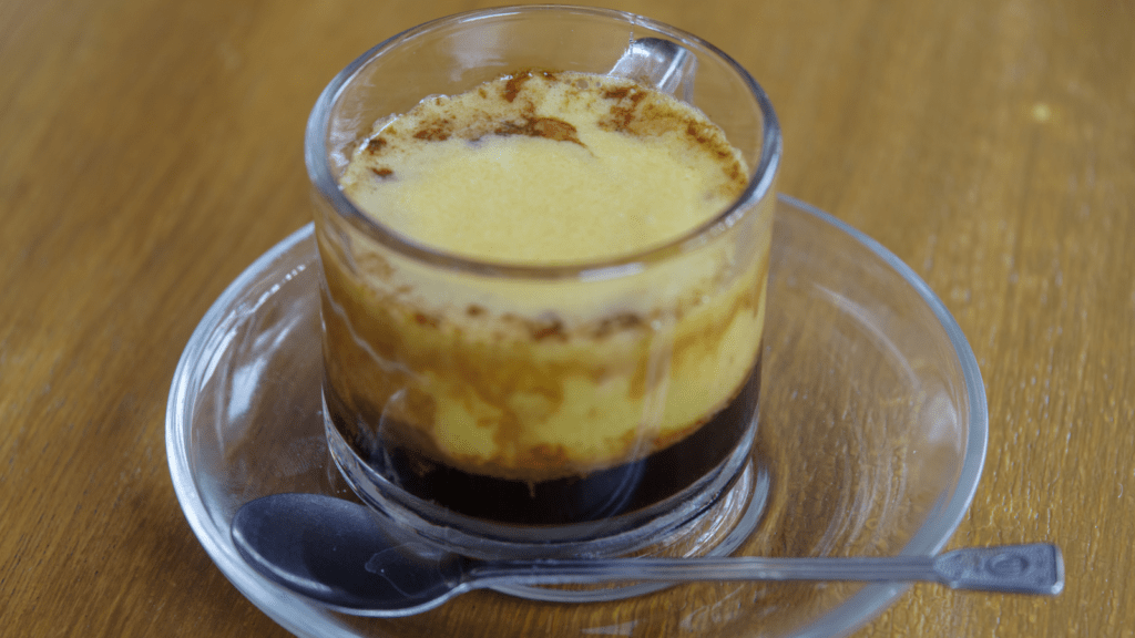 Traditional Vietnamese Egg coffee in a glass tea cup.