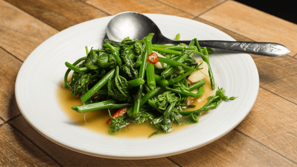 Plate of stir-fried morning glory in a soy and garlic sauce.