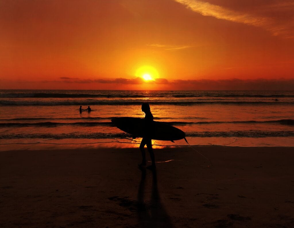 Surfer at sunset on a beach in Kuta, Indonesia