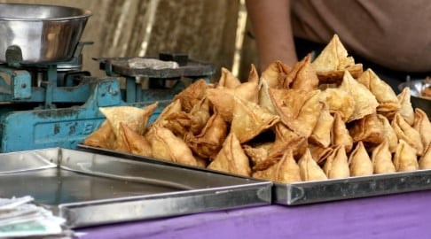 Triangle Samosas stacked on a tray