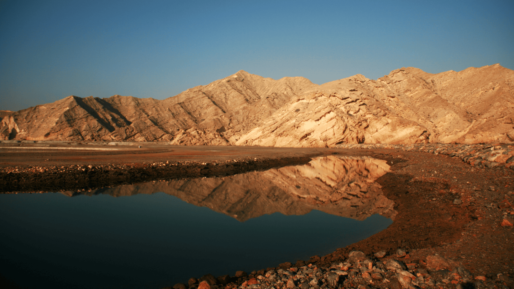 Reflection of hills on water in Yiti Beach, Oman