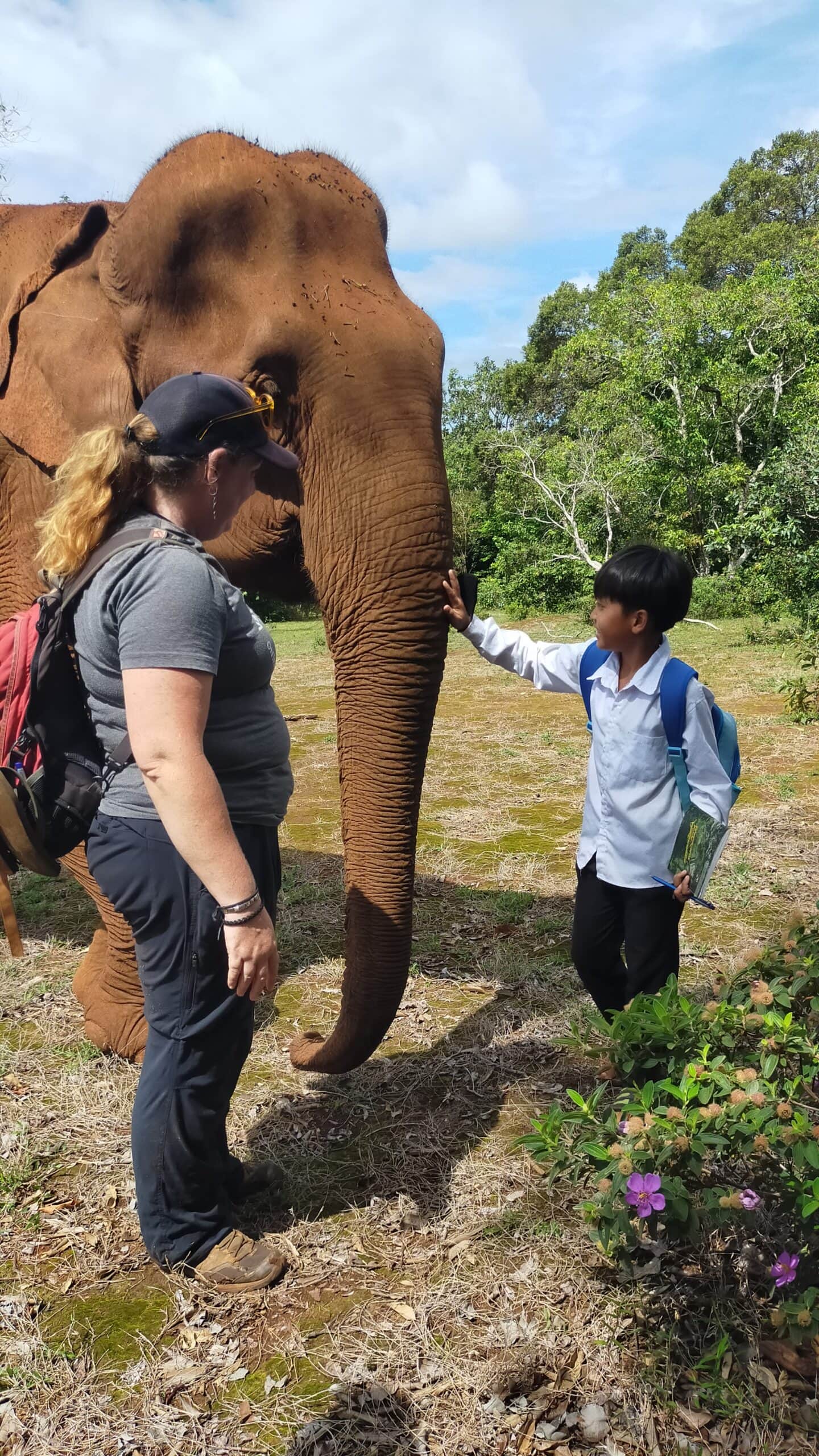 A child experiences meeting an elephant under supervision from an adult at Elephant Valley Project, Mondulkiri, Cambodia