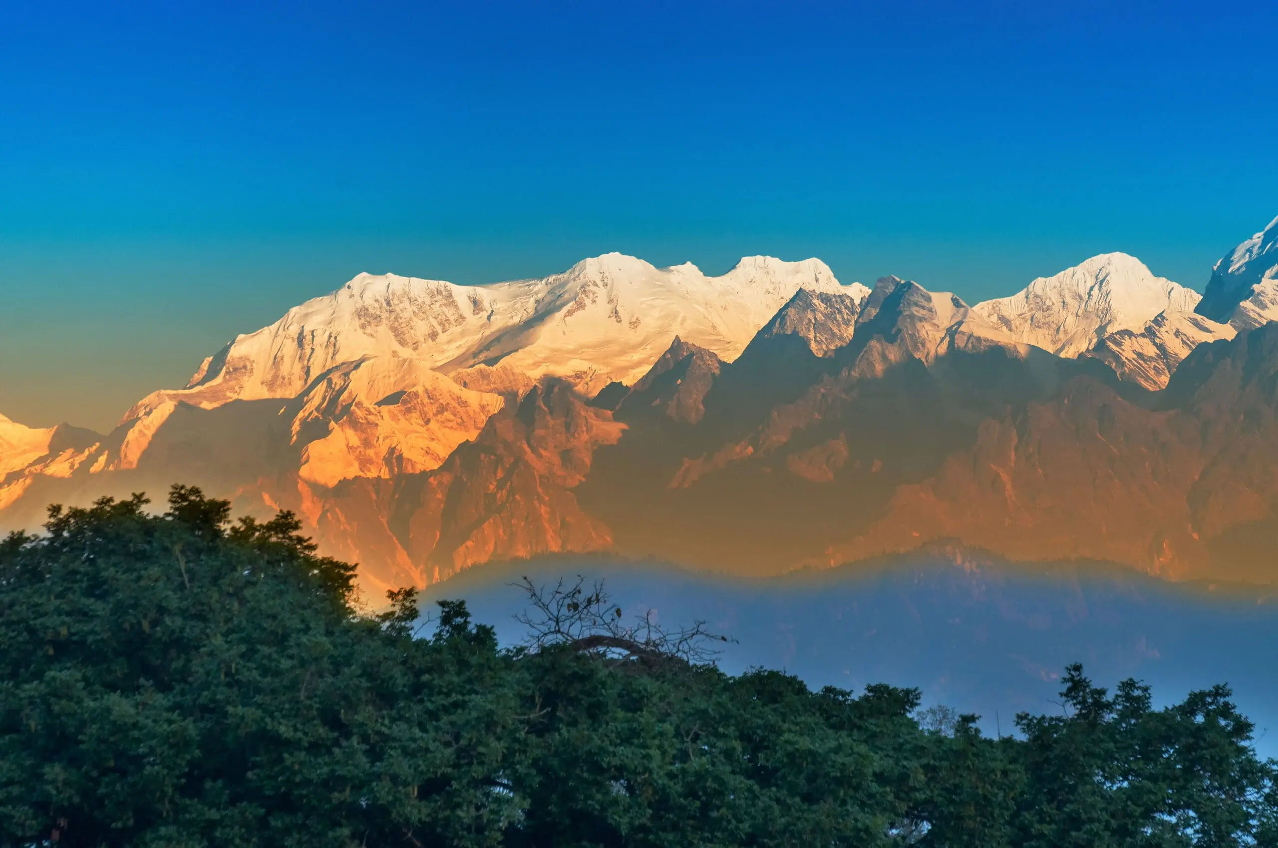 Beautiful first light from sunrise on Mount Kanchenjungha, Himalayan mountain range, Sikkim, India. Orange tint on the mountains at dawn.