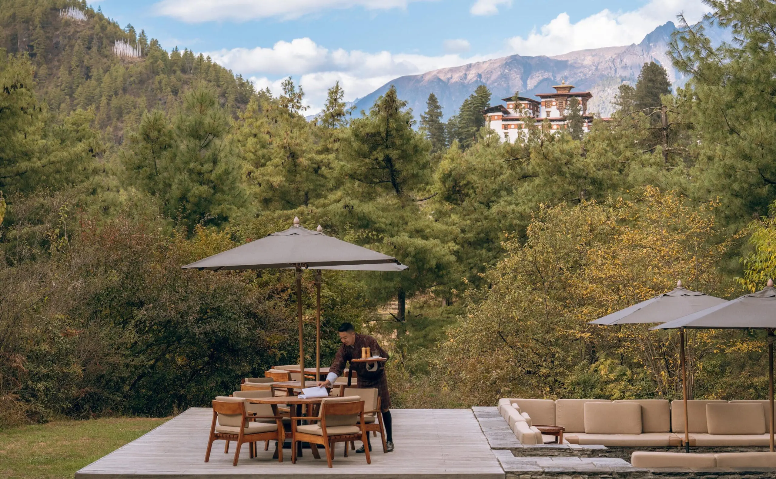 Meal being served outdoors with a mountain view by staff at Amankora Paro