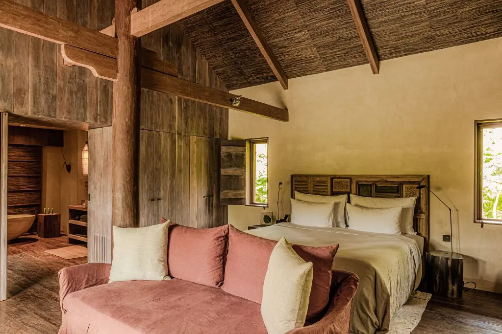 Rustic luxury bedroom at Phum Baitang resort Cambodia with wooden interiors