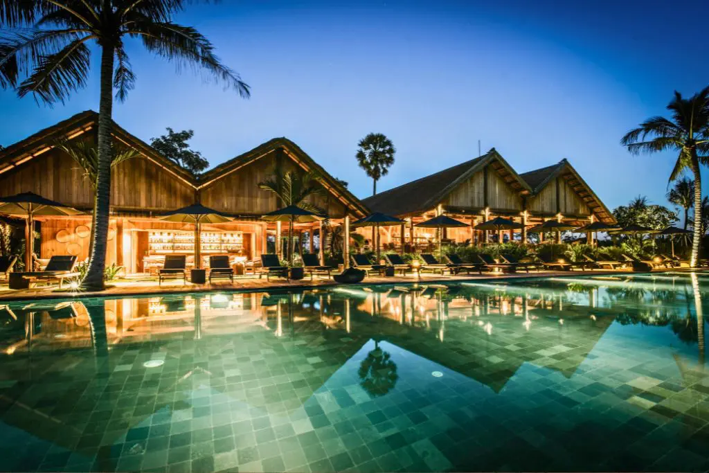 Illuminated pool and villas at Phum Baitang resort Cambodia at night