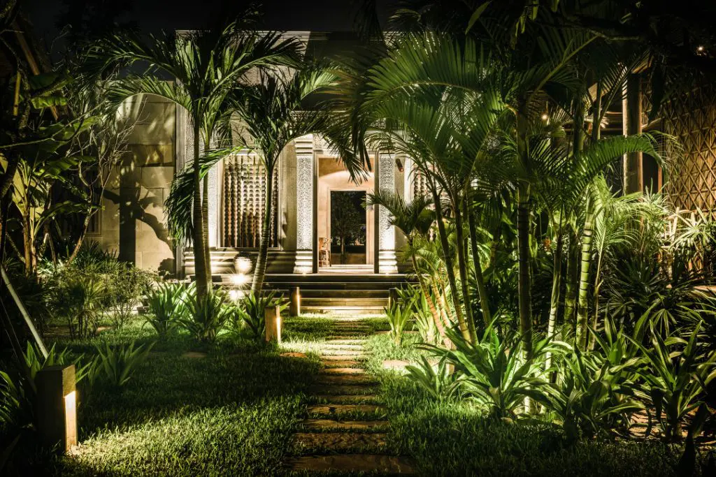 Tropical villa exterior at Phum Baitang resort Cambodia surrounded by gardens at night