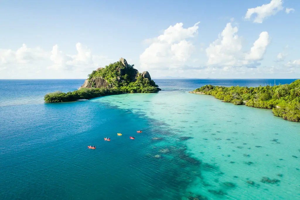 Kayaking in turquoise lagoon at Bawah Reserve Indonesia tropical island
