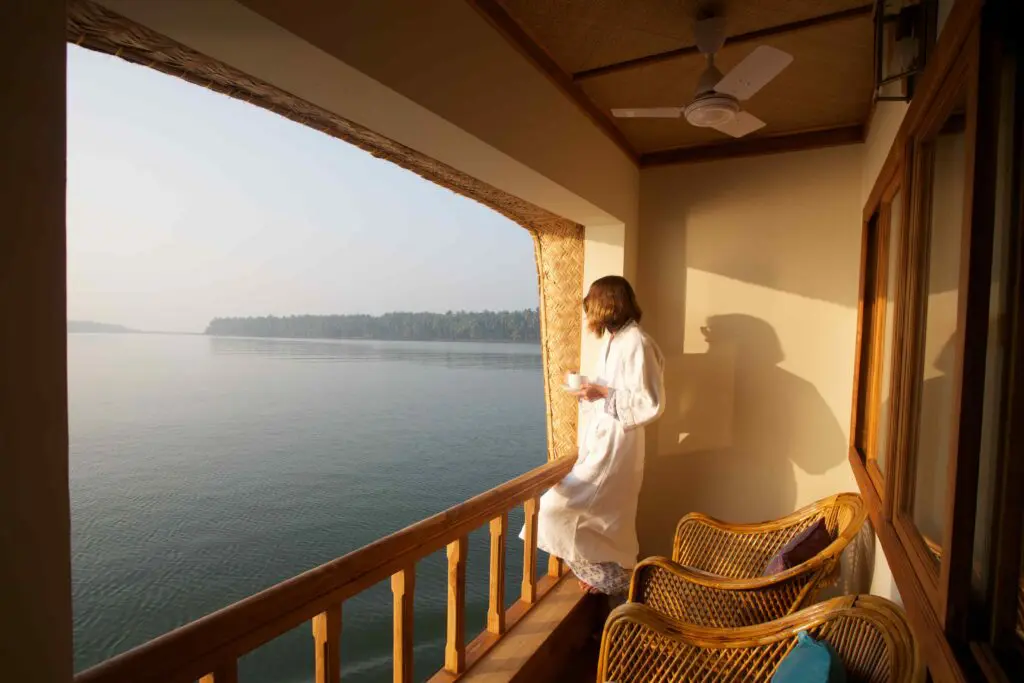 Luxury houseboat in Kerala backwaters with guest enjoying morning view