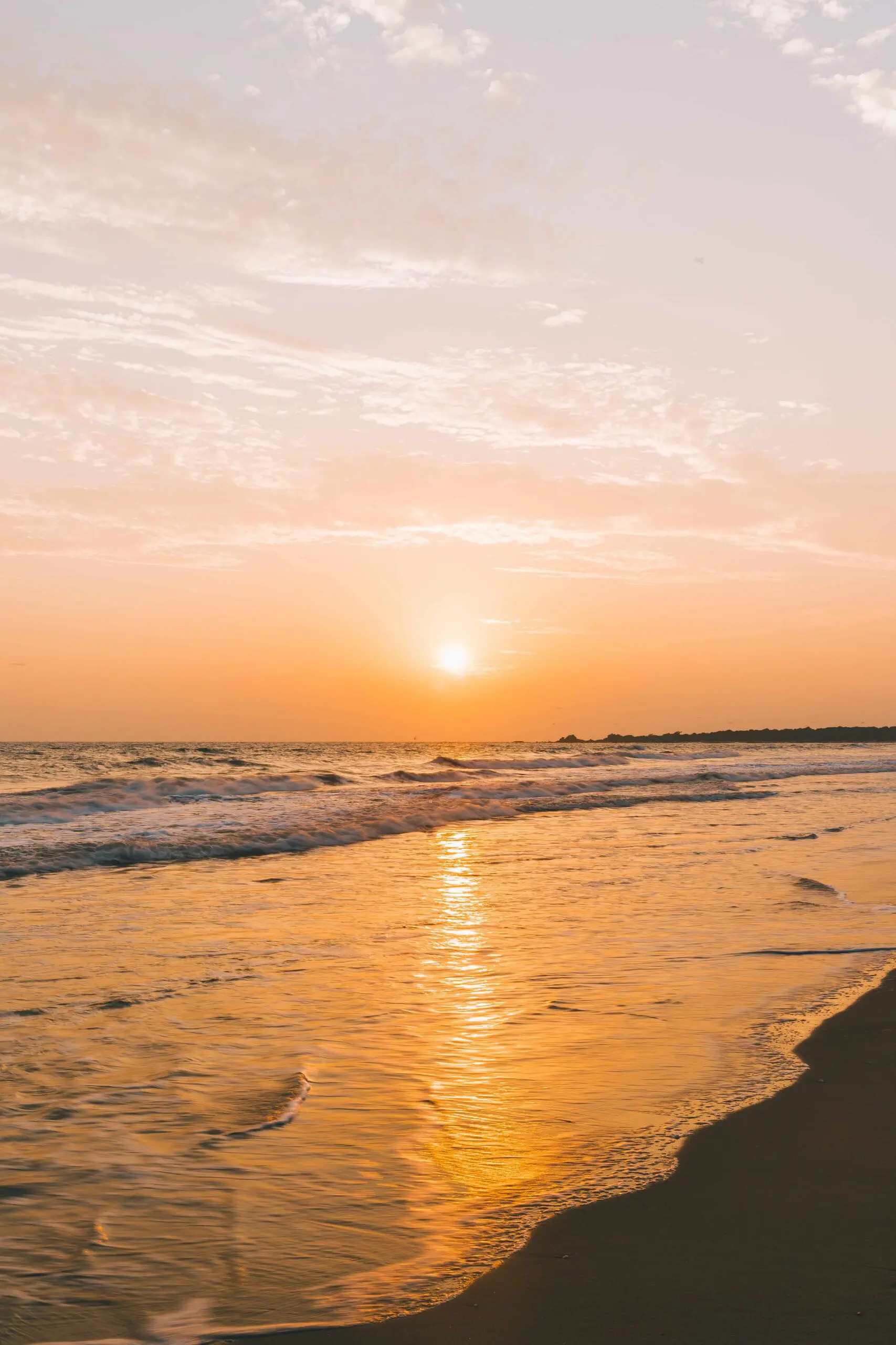 Golden sunset over quiet beach with gentle waves in Sri Lanka
