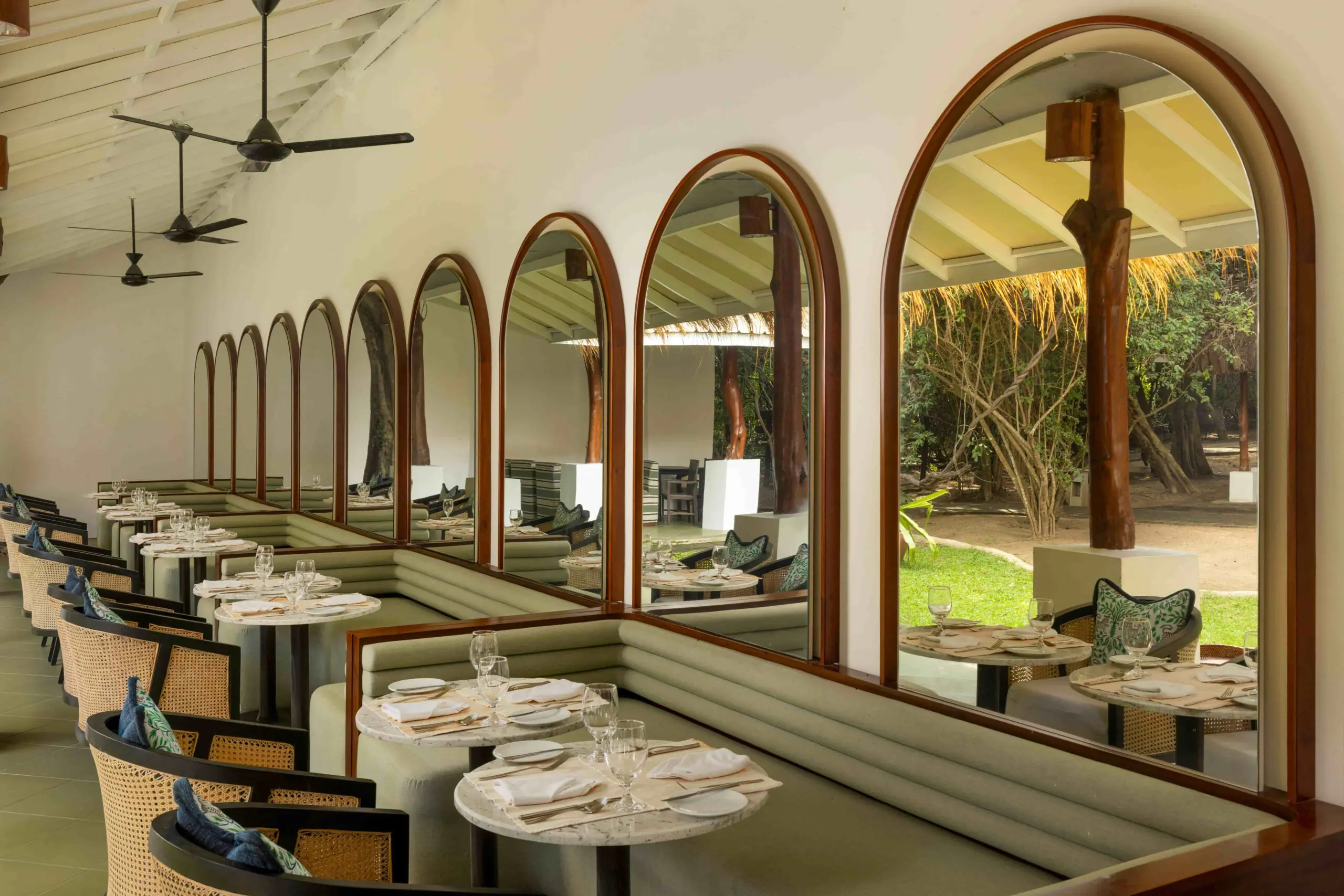Open-air restaurant at Uga Jungle Beach with arched windows and garden views