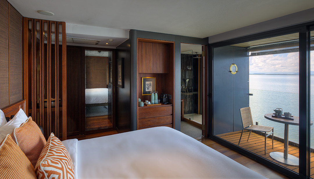 Design Suite on Aqua Mekong with floor-to-ceiling doors opening onto river-view balcony